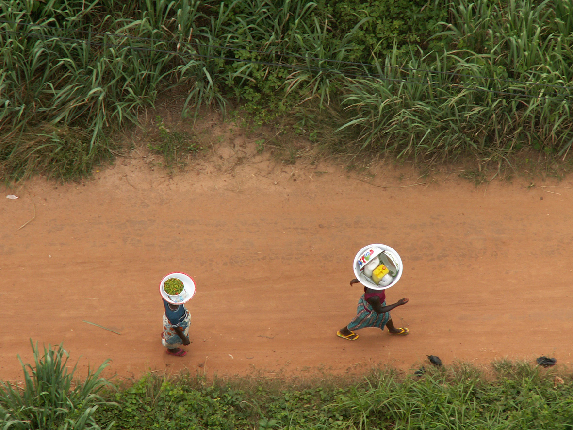 2 afrikanische Frauen transportieren Waren auf ihrem Kopf
