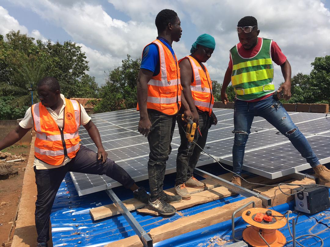Männer auf einem Dach bei der Installation einer PV-Anlage
