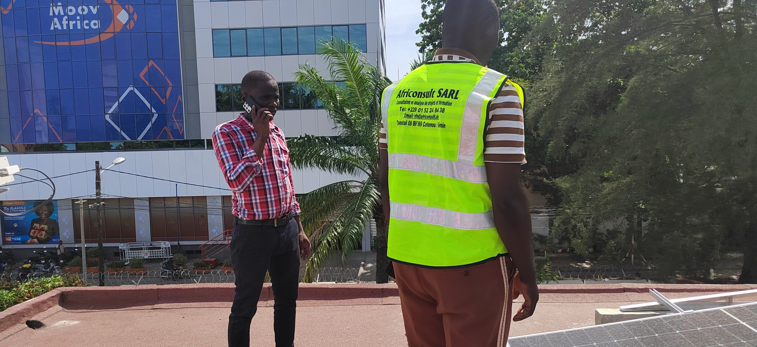 Mitarbeiter von Africonsult auf einem Dach mit PV-Anlage