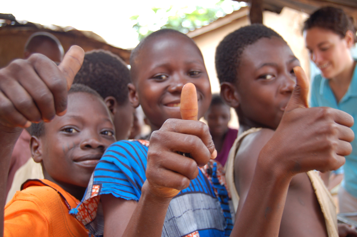 Kinder halten den Daumen in die Kamera